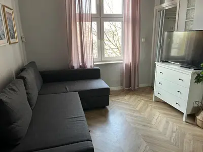 a living room with a couch and a tv at Nowy Kleparz Apt in Kraków