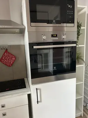 a kitchen with a stove and a microwave at Nowy Kleparz Apt in Kraków