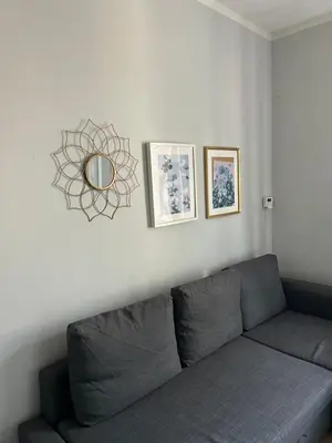 a living room with a couch and a mirror on the wall at Nowy Kleparz Apt in Kraków