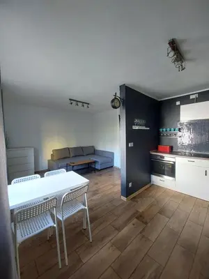 a living room with a stone fireplace and a table at Sunny Family Zator Energylandia in Zator