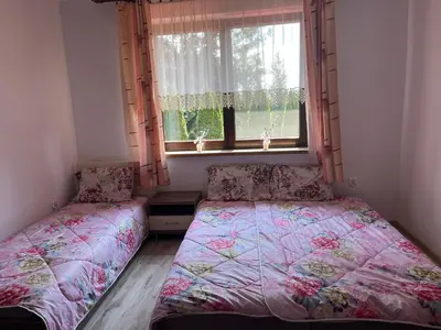a bedroom with two beds in front of a window at HOTEL&RESTAURACJA DALLAS LuxUSAPL - 2026 NOWA WŁAŚCICIELKA ZAPRASZA!! in Myślenice