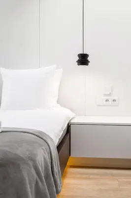 a bedroom with a white bed and a night stand at Househost Apartment Miodowa 42 20 in Kraków