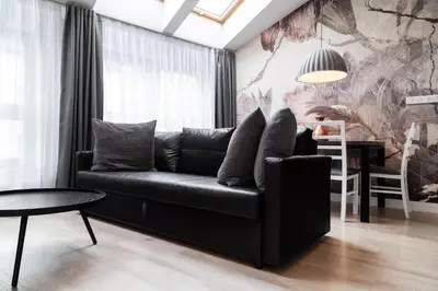 a living room with a black couch and a table at Househost Apartment Miodowa 42 20 in Kraków