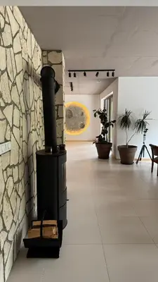 a fireplace in a room with a stone wall at Jaśminowa Pracownia in Rupniów