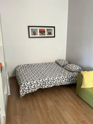 a bedroom with a bed in the corner of a room at Hala Targowa Apartament in Kraków