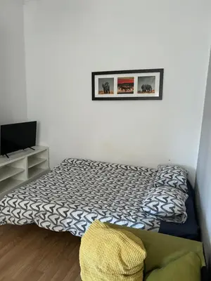 a small bedroom with a bed and a television at Hala Targowa Apartament in Kraków