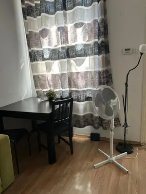 a desk and a fan in a room with a curtain at Hala Targowa Apartament in Kraków