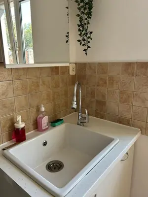 a white sink in a kitchen with a mirror at Hala Targowa Apartament in Kraków