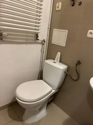 a bathroom with a toilet with a phone on top of it at Planty Apartament in Kraków