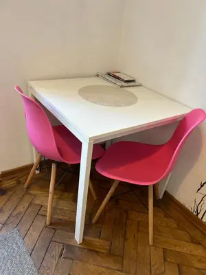 a white table with two pink chairs in a room at Planty Apartament in Kraków