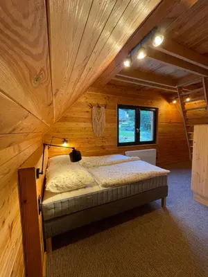 a bedroom with a bed in a wooden cabin at Chałpy H700 in Koszarawa