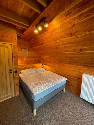 a bedroom with a bed in a wooden room at Chałpy H700 in Koszarawa