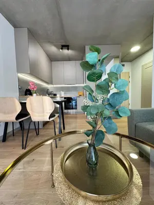 a living room with a vase with a plant on a table at Piast Apartment - free parking in Kraków