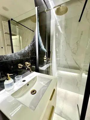 a white bathroom with a sink and a shower at Piast Apartment - free parking in Kraków