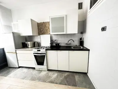 a white kitchen with a sink and a stove at Mateczny in Kraków
