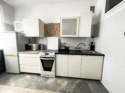a white kitchen with a stove and a sink at Mateczny in Kraków