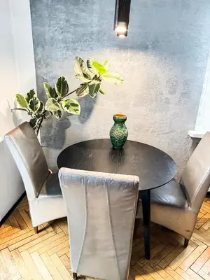 a black table with chairs and a vase on it at Mateczny in Kraków
