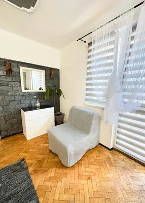 a living room with a chair and a window at Mateczny in Kraków