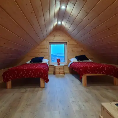 two beds in a room with a window at Domek pod Skiełkiem in Łukowica