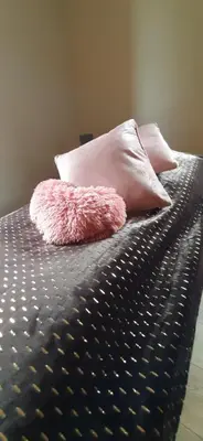 a pink stuffed animal sitting on a bed with two pillows at Domek pod Skiełkiem in Łukowica