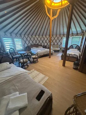 a room with beds and tables in a yurt at Brzozowy Zagajnik in Inwałd
