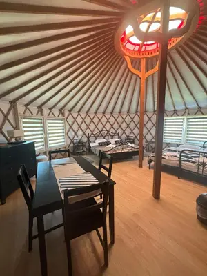 a room with a table and a cross in a yurt at Brzozowy Zagajnik in Inwałd