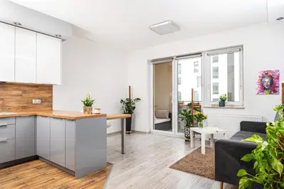 an apartment kitchen and living room with a couch at Apartament Bonarka-Podgórze in Kraków
