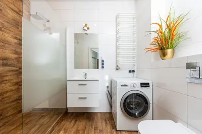 a white bathroom with a washer and dryer at Apartament Bonarka-Podgórze in Kraków