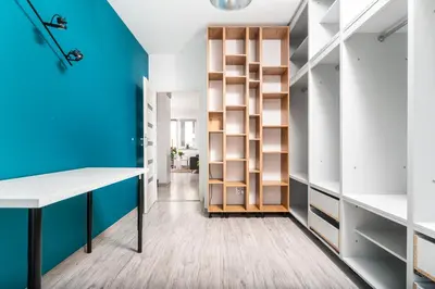 a dressing room with blue walls and wooden shelves at Apartament Bonarka-Podgórze in Kraków