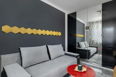 a living room with a couch and a table at Modern Apartment with a Balcony in a Quiet Estate by Noclegi Renters in Kraków
