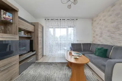 a living room with a couch and a table at Modern Apartment with a Balcony in a Quiet Estate by Noclegi Renters in Kraków