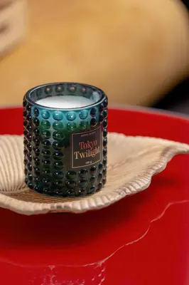 a black candle on a plate on a red table at Modern Apartment with a Balcony in a Quiet Estate by Noclegi Renters in Kraków