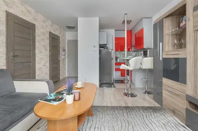 a living room with a couch and a table at Modern Apartment with a Balcony in a Quiet Estate by Noclegi Renters in Kraków