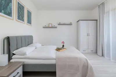 a white bedroom with a bed and a table at Bright Apartment in Cracow Center with Terrace, Desk and Bathtub by Noclegi Renters in Kraków
