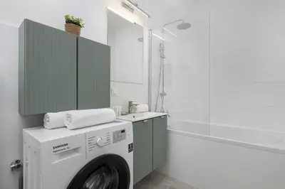 a bathroom with a washing machine and a sink at Bright Apartment in Cracow Center with Terrace, Desk and Bathtub by Noclegi Renters in Kraków