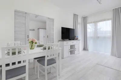a white kitchen with a desk and a television at Bright Apartment in Cracow Center with Terrace, Desk and Bathtub by Noclegi Renters in Kraków