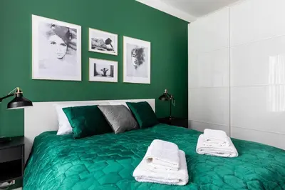 a bedroom with a green bed with two towels on it at Green Boutique Apartment 60m2 & Garage in Kraków
