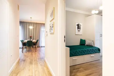 a bedroom with a green bed and a dining room at Green Boutique Apartment 60m2 & Garage in Kraków