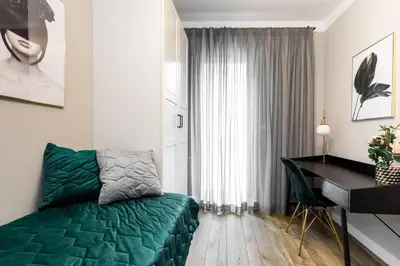 a bedroom with a green bed and a desk at Green Boutique Apartment 60m2 & Garage in Kraków