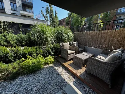 a garden with two chairs and a bench and plants at Green Boutique Apartment 60m2 & Garage in Kraków
