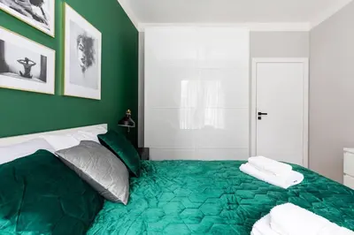 a bedroom with green walls and a bed with pillows at Green Boutique Apartment 60m2 & Garage in Kraków