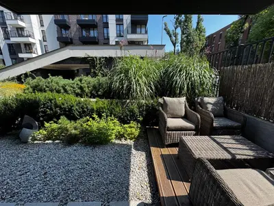 a garden with a patio with chairs and a fence at Green Boutique Apartment 60m2 & Garage in Kraków