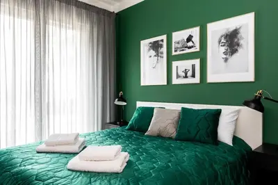 a green bedroom with a bed with two towels on it at Green Boutique Apartment 60m2 & Garage in Kraków
