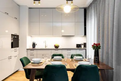 a dining room with a wooden table and green chairs at Green Boutique Apartment 60m2 & Garage in Kraków