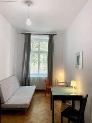 a living room with a couch and a table and a window at Enios Rooms ul Jana kochanowskiego 26 in Kraków