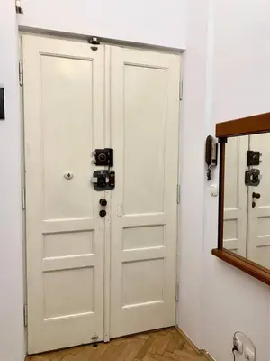 a white door in a room with a mirror at Enios Rooms ul Jana kochanowskiego 26 in Kraków