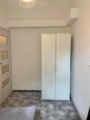 a white cabinet in a room with a wall at Enios Rooms ul Jana kochanowskiego 26 in Kraków