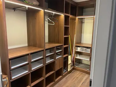 a walk in closet with wooden cabinets and wooden floors at Monte Cassino Apartament in Oświęcim