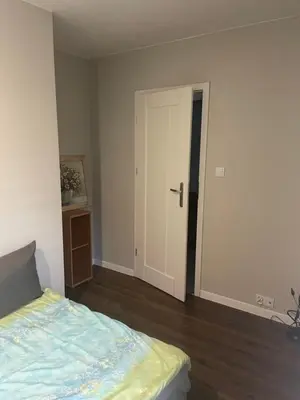 an empty room with a bed and a door at Monte Cassino Apartament in Oświęcim