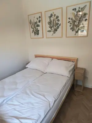 a bed in a room with two pictures on the wall at Domki na Górkach in Spytkowice